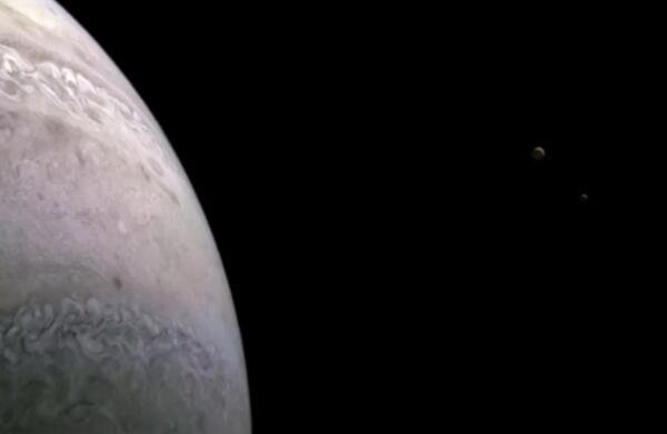 在 2022 年 1 月 12 日朱诺号第 39 次近距离飞越木星期间拍摄，这张令人惊叹的照片捕捉到了木星的两个卫星：木卫一（左）和欧罗巴（右）.jpg
